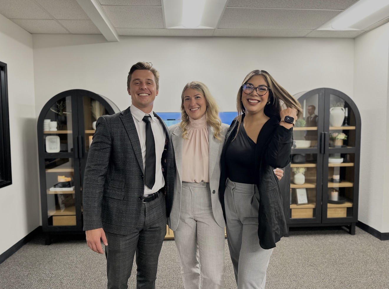 Three ASAP team members smiling together in the office